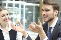 Bild von einem Mann, der seiner Kollegin etwas erzählt rund um den Ratgeber zum MBI Leitfaden